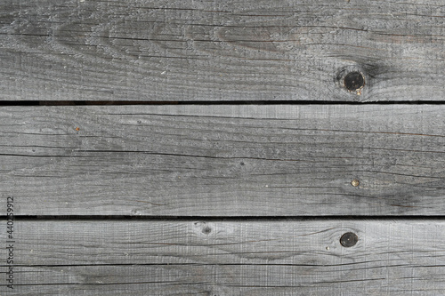 The texture of old rough wooden planks, cracked by weather and time.