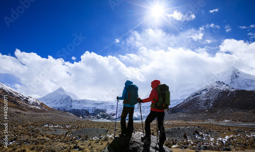 Two women hikers hiking in winter high altitude mountains