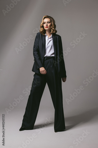 Stylish business successful confident woman in black work suit. Businesswoman in an oversized jacket looking forward. Goal setting. headway ahead . Work dress code. Men's suit. Red lipstick. feminist