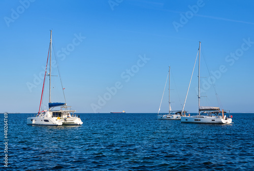 Sailing yacht catamarans, Mediterranean sea, clear blue sky and sea waters. Summer entertainment, fun sailing, swimming, Greek islands, seascape.