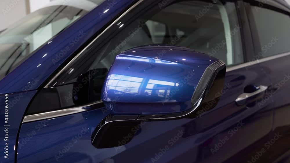 Close up of a rearview mirror of modern blue car with turn signal. Close up of a rearview mirror of modern blue car with turn signal.