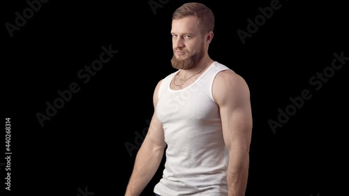 Caucasian man with a beard looking at the camera. Look ahead on a black background. High quality photo © Vladimir