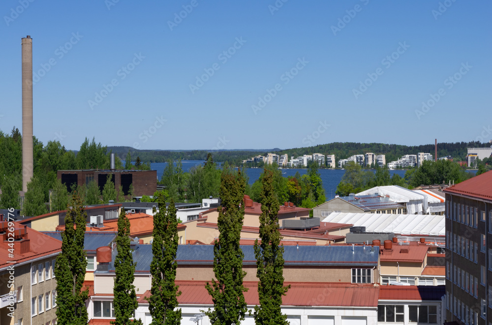 trees, house roofs and a lake behind roofs