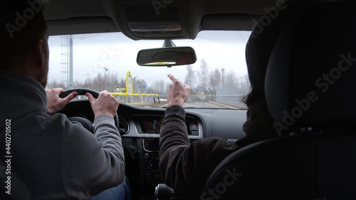 Passenger and driver inside modern car driving at industrial site © nimito