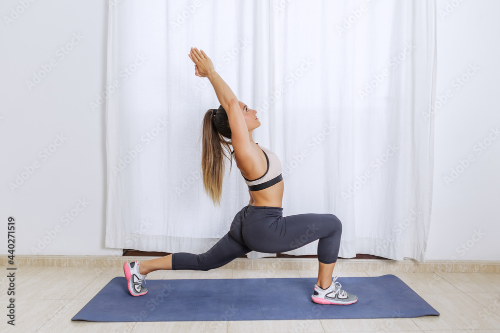 Young woman stretching body in Crescent lunge pose