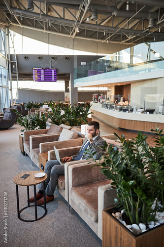 Businessman enjoying his beverage before the international flight photo