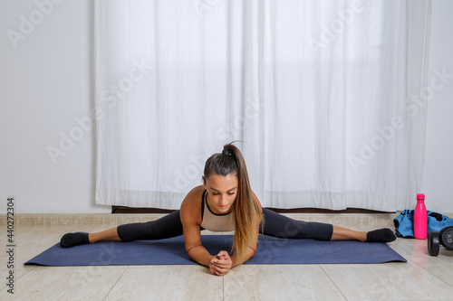 Fit woman stretching body in Side Splits pose