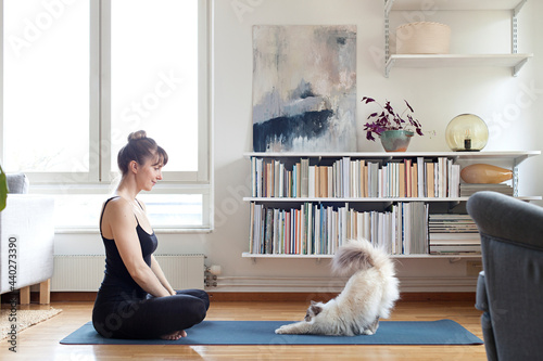 Woman with cat on yoga mat photo