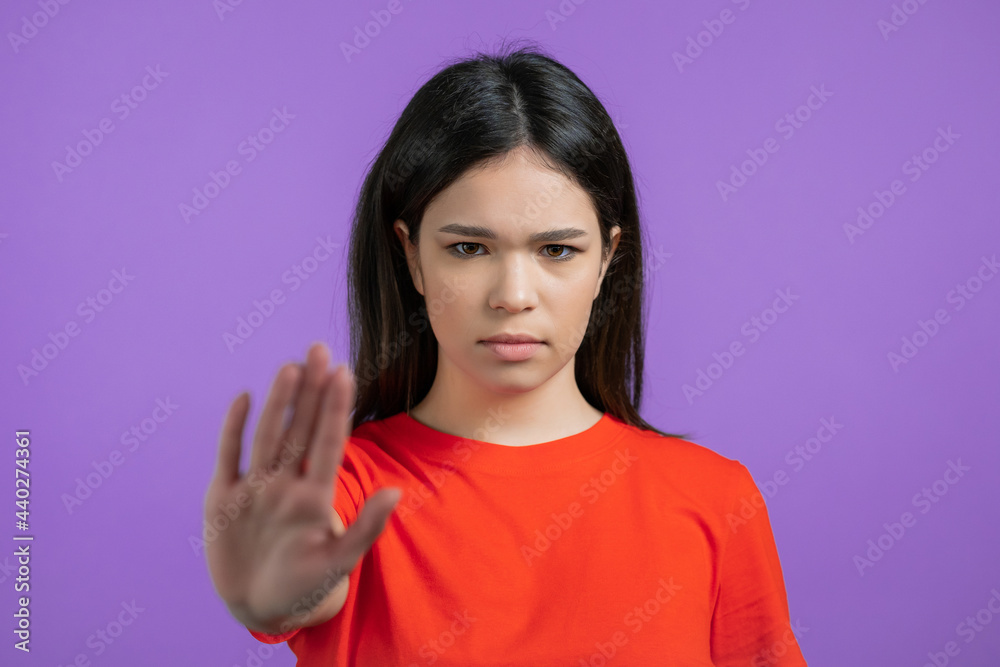 Pretty woman disapproving with NO hand sign gesture. Denying, rejecting, disagree, portrait of beautiful girl on violet background Pretty woman disapproving with NO hand sign gesture. Denying, rejecting, disagree, portrait of beautiful girl on violet background