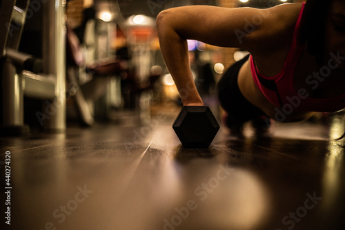 Sport and recreation concept. Sporty woman hands with black dumbbells.