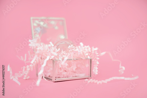 pink wrapping paper in glass box on pink background