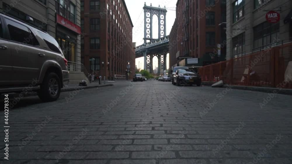 Brooklyn Bridge View from Dumbo with dumbo apartment houses and parked cars on the side in Summer in early morning light Brooklyn Bridge View from Dumbo with dumbo apartment houses and parked cars on the side in Summer in early morning light