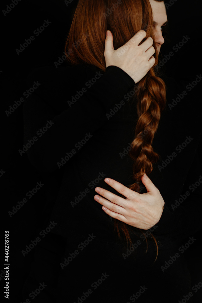 Cropped anonymous couple standing in studio on black background Cropped anonymous couple standing in studio on black background