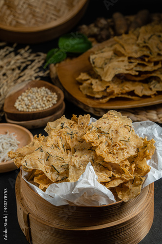 Rempeyek or peyek ikan teri, a deep-fried savoury Indonesian-Javanese cracker made from flour (usually rice flour), lime leaves and other ingredients, bound or coated by crispy flour batter photo