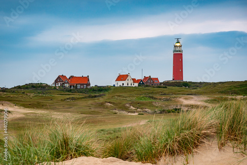 Red lighthouses and houses with red roofs in the dunes on Texel island in the Netherlands.