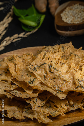 Rempeyek or peyek ikan teri, a deep-fried savoury Indonesian-Javanese cracker made from flour (usually rice flour), lime leaves and other ingredients, bound or coated by crispy flour batter photo