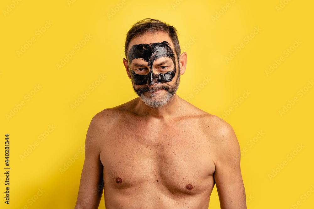 Shirtless man with clay mask on face Shirtless man with clay mask on face