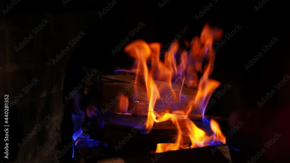 Beautiful bright fire flames. Wooden logs are burning in red and yellow fire on dark background. Close-up. Beautiful bright fire flames. Wooden logs are burning in red and yellow fire on dark background. Close-up.