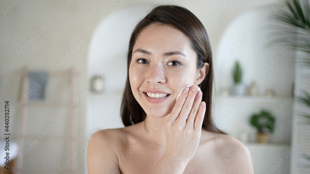 Attractive young multi ethnic woman after bath cleaning skin and pores holds cotton pad uses gel biphasic cleanser removing make up and dirt enjoy effective beauty treatment cosmetics bodycare concept Attractive young multi ethnic woman after bath cleaning skin and pores holds cotton pad uses gel biphasic cleanser removing make up and dirt enjoy effective beauty treatment cosmetics bodycare concept