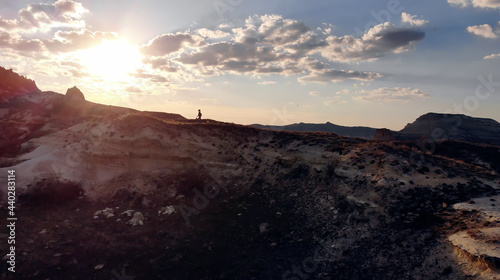 AIR. Drone photo silhouette of a woman on a mountain in the morning with vintage light