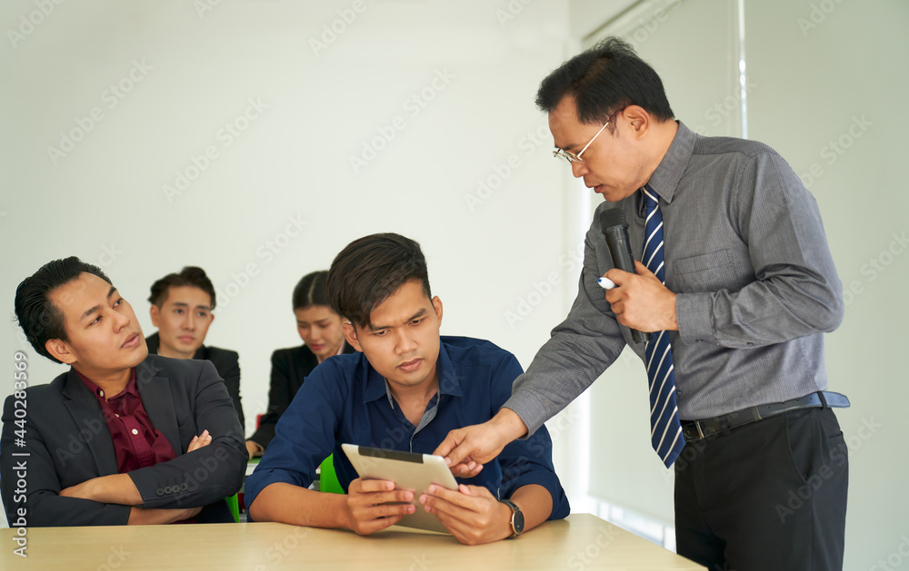 Seminar advisor suggest the audience by pointing on tablet to explain solution or question Seminar advisor suggest the audience by pointing on tablet to explain solution or question
