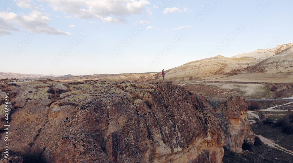Obraz premium AIR. Drone photo silhouette of a woman on a mountain in the morning with vintage light