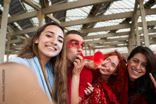 POV selfie. Group of fans take photo while cheering for their sports team from a stadium. Cheerful male and female fans taking selfie while watching the game at the stadium. photo