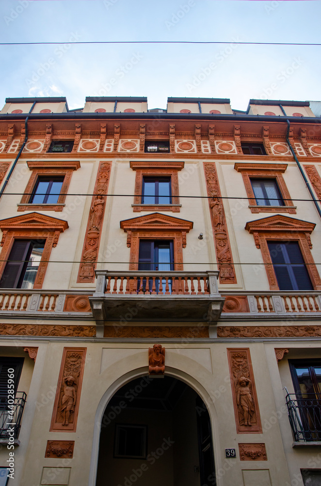 Obraz premium Details of a facade of an old Milan style building. Via Bramante. Chinatown. Italy. Inlays, friezes and bas-reliefs 