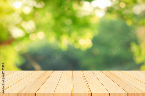 Wood floor with blurred trees of nature park background and summer season  product display montage