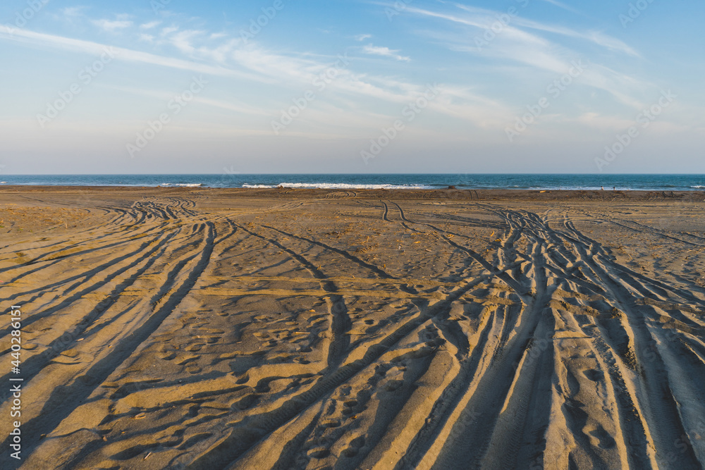 Naklejka premium 青空と砂浜に作られたタイヤの跡