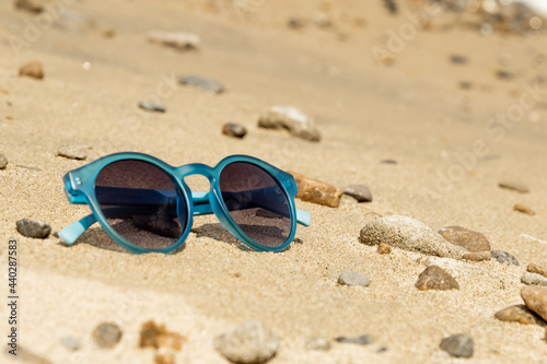 blue sunglasses on the sand