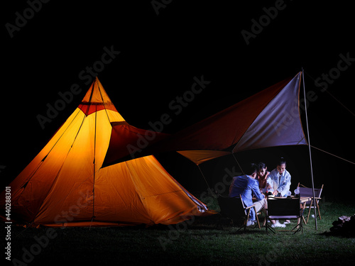 A Happy family of three camping outdoors