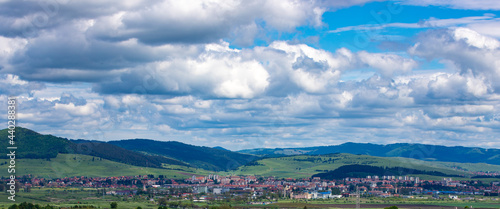 Rural houses and mountains under a cloudy sky in Gheorgheni, Harghita County, Romania photo