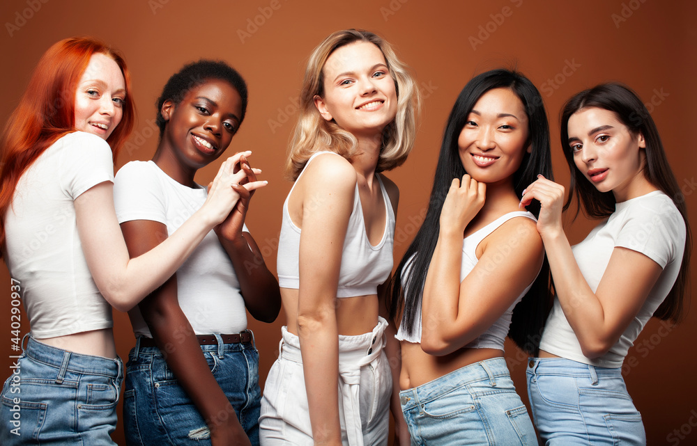 young pretty caucasian, afro, asian, scandinavian woman posing cheerful together on brown background, lifestyle diverse nationality people concept young pretty caucasian, afro, asian, scandinavian woman posing cheerful together on brown background, lifestyle diverse nationality people concept