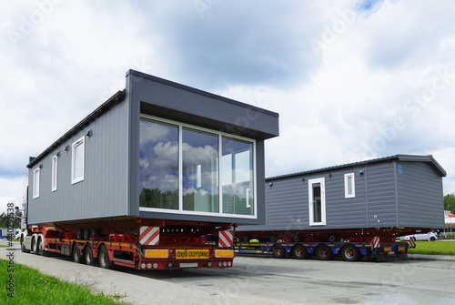 Oversized cargo or exceptional convoy (convoi exceptionnel). A truck with a special semi-trailer for the transport of oversized cargo - transport of finished houses. photo