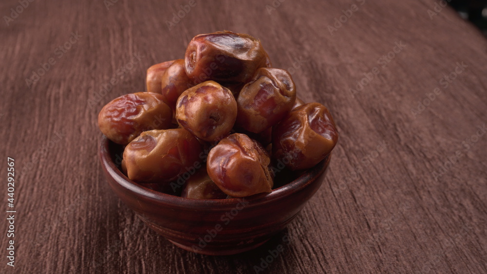 Obraz premium Dates in wooden bowl on background. dried dates fruit.