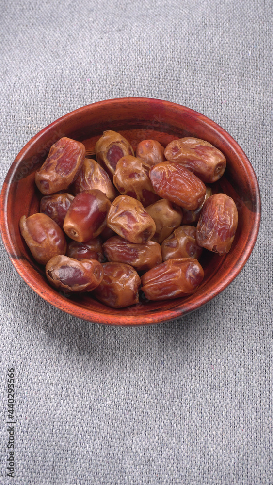 Dates in wooden bowl on background. dried dates fruit. Dates in wooden bowl on background. dried dates fruit.