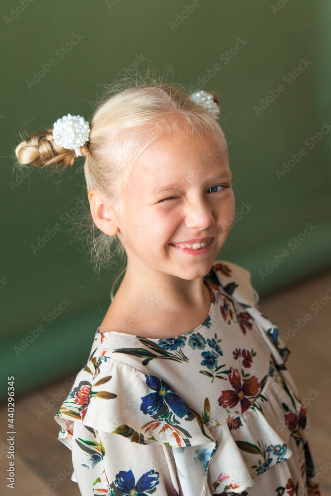 Beautiful blonde girl with a hairstyle in the form of two horns on an olive green background. Great for demonstrating the character of a child - daydreaming, enthusiasm, vulnerability, stubbornness. Beautiful blonde girl with a hairstyle in the form of two horns on an olive green background. Great for demonstrating the character of a child - daydreaming, enthusiasm, vulnerability, stubbornness.