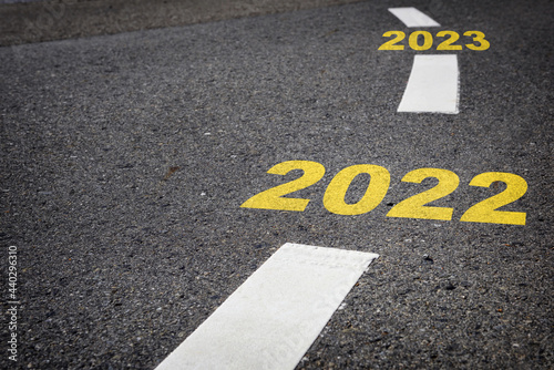 2022 to 2023 on black asphalt road and white marking lines. Start to happy new year and road to success concept