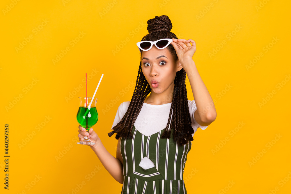 Portrait of attractive amazed girl drinking juice having fun pout lips rest relax isolated over bright yellow color background Portrait of attractive amazed girl drinking juice having fun pout lips rest relax isolated over bright yellow color background