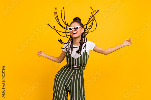 Photo of young black girl happy positive smile fly air hair wear sunglass summer isolated over yellow color background
