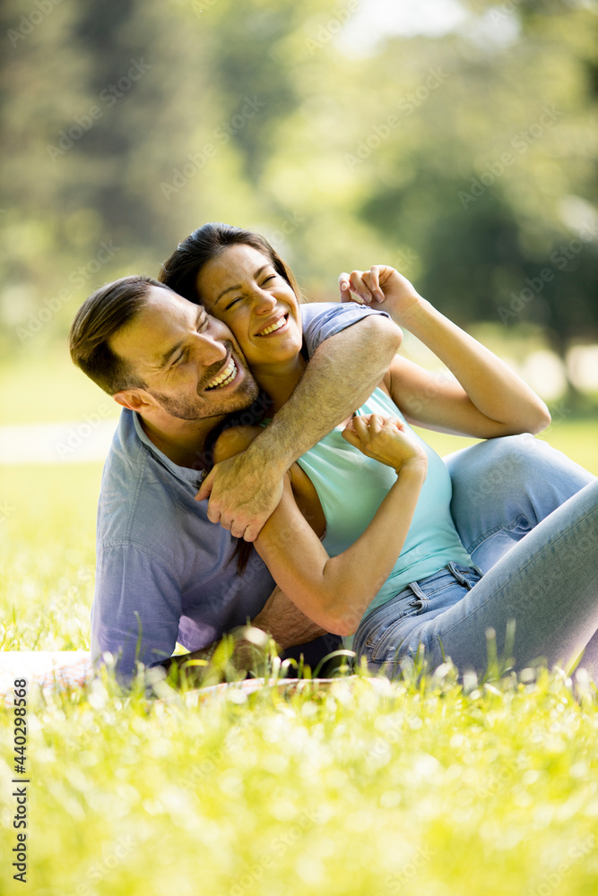 Affectionate young couple sitting on the green grass Affectionate young couple sitting on the green grass