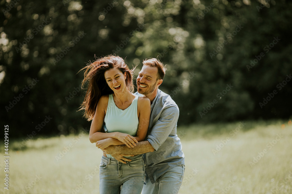 Fototapeta premium Affectionate young couple having fun on the green grass