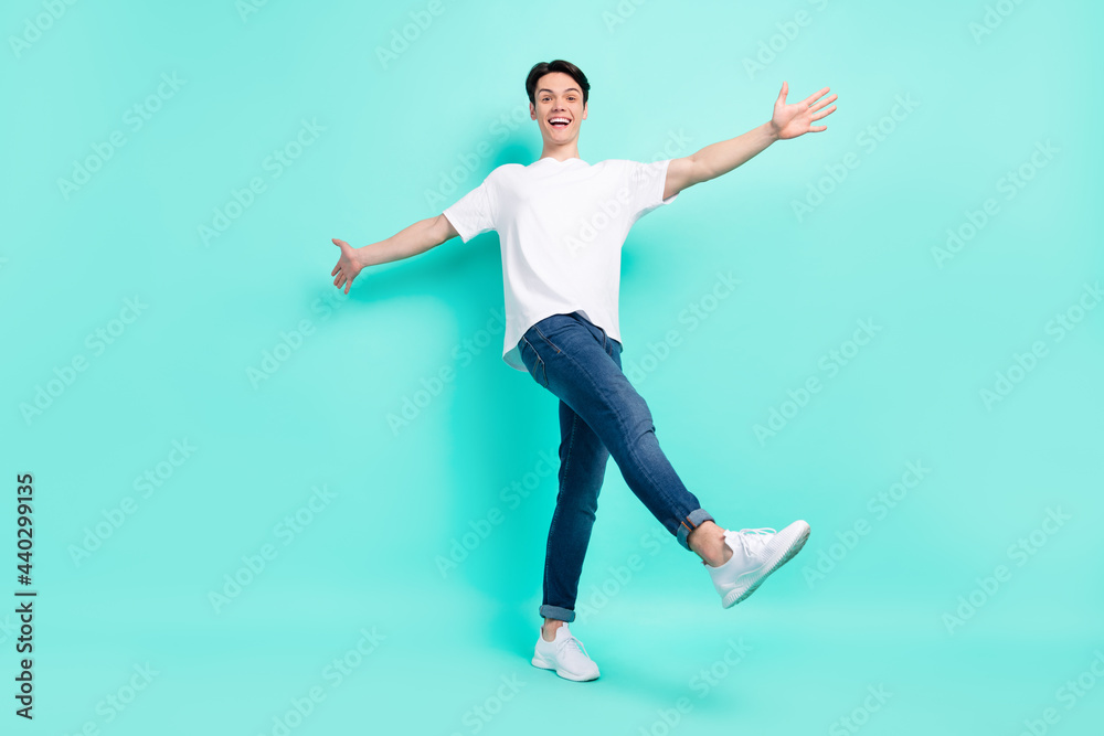 Full body photo of cool brunet hairdo teen guy dance wear t-shirt jeans isolated on vibrant teal color background Full body photo of cool brunet hairdo teen guy dance wear t-shirt jeans isolated on vibrant teal color background