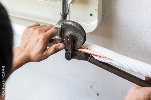 Man hands bends copper pipes by pipe bender. Air conditioner technician hands bends copper pipes by pipe bender. Pipe bender tool in a hands of factory worker on Site. Fitter is bending a pipe.