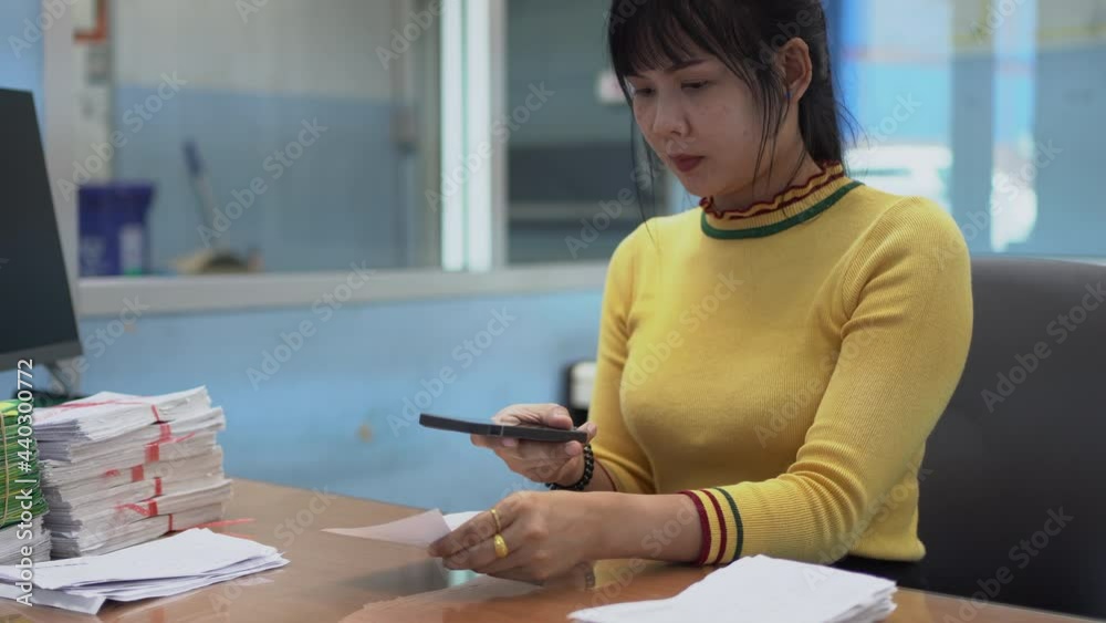 Asian woman hold smart phone to reader or scan barcode for transfer data to computer. Asian woman hold smart phone to reader or scan barcode for transfer data to computer.