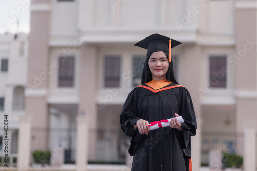 Female graduates happily celebrate university graduation with diploma