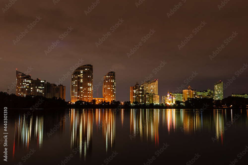 Fototapeta premium night city with reflection of houses in the river