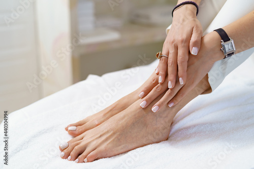 Manicure pedicure close up on white perfect shape hands spa salon