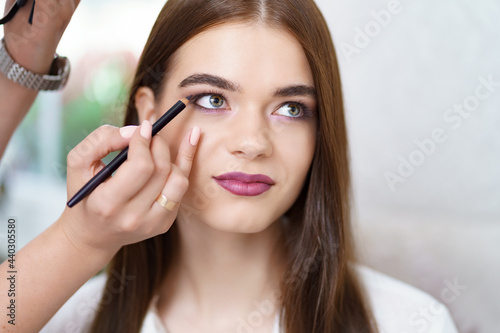 Professional makeup artist working with client in dressing room